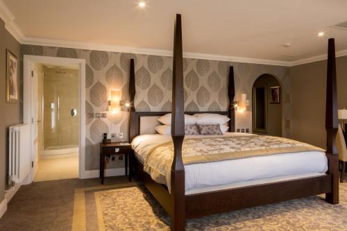 a bedroom with a large bed and a walk in shower at Oakley Hall Hotel in Basingstoke
