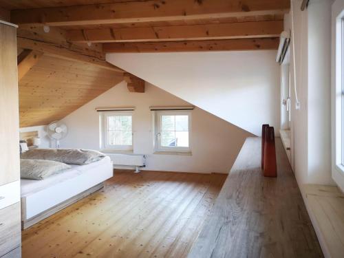 an attic bedroom with a bed and two windows at Haus Matzenblick in Reith im Alpbachtal
