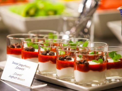 a tray of desserts in glass cups on a table at Qubus Hotel Wrocław in Wrocław