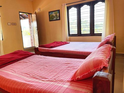 a bedroom with two beds and a window at Sandev Homestay in Madikeri