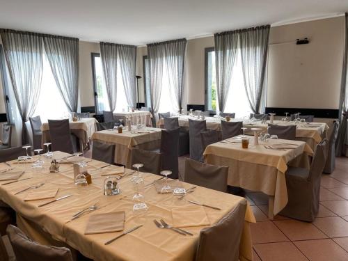 una habitación llena de mesas y sillas con mesa en Albergo del mera-ristorante da Lui, en Sorico