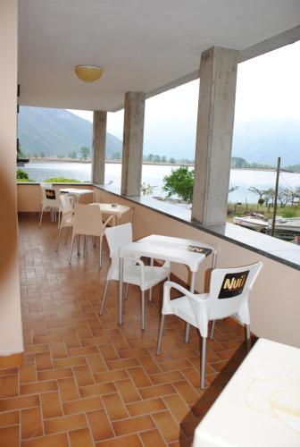 a restaurant with tables and chairs and a view of the water at Albergo del mera-ristorante da Lui in Sorico