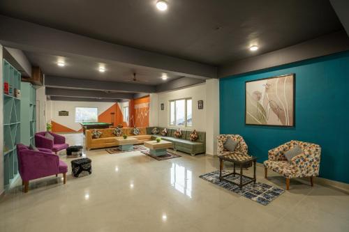 a living room with purple furniture and blue walls at Zostel Plus Kareri in Dharamshala