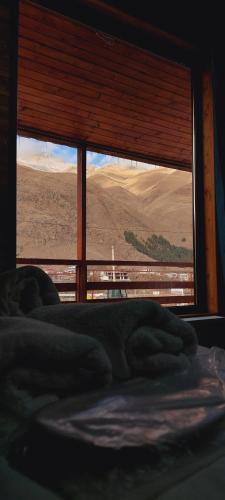 a bed in a room with a large window at Guesthouse and Cottage Nicolo in Stepantsminda