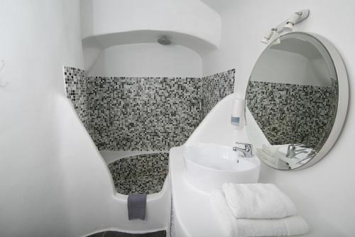 a bathroom with a sink and a mirror at Vogue Suites in Oia