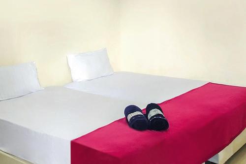 a pair of shoes sitting on top of a bed at Fabel Homestay in Palembang