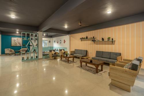 a large living room with couches and tables at Zostel Plus Kareri in Dharamshala