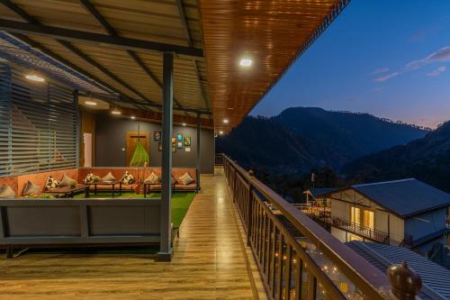 a balcony of a house with a view of the mountains at Zostel Plus Kareri in Dharamshala