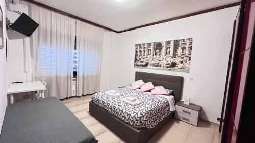 ローマにあるBella Roma Guest Houseのベッドルーム1室(ピンクの枕とデスク付)
