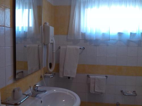 baño con lavabo y ventana con toallas en Hotel San Francesco Terme, en Spezzano Albanese