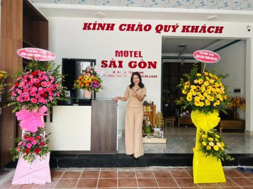 una mujer parada frente a una floristería en Sai Gon Motel, en Da Nang