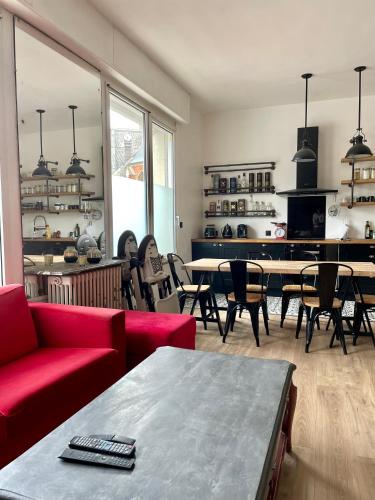 ein Wohnzimmer mit einem roten Sofa sowie Tischen und Stühlen in der Unterkunft Le Remède - villa de 180m2 à 3mn de la plage Ault in Ault