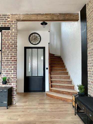 a black door with a clock on a brick wall at Le Remède - villa de 180m2 à 3mn de la plage Ault in Ault