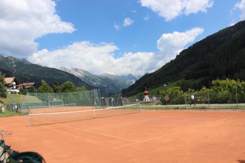 a tennis court with mountains in the background at Ferienhaus Gundi in Pettneu am Arlberg