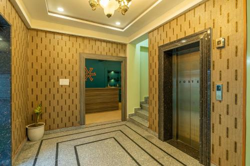 eine Lobby eines Hotels mit einer Glastür und einer Treppe in der Unterkunft Zostel Plus Kareri in Dharamshala