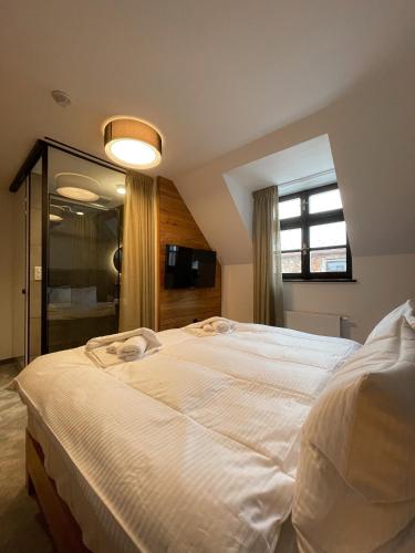 a large white bed in a bedroom with a window at DOMA u nás Boutique hotel & spa in Poprad