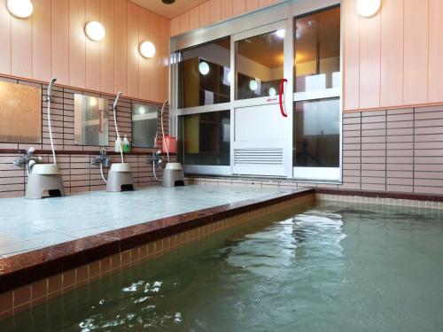 una piscina con agua en medio de un edificio en Hotel Meribel Tsugaike, en Otari