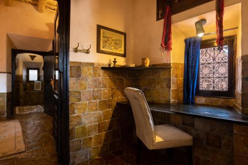 a stone bar with a chair in a room at Kasbah Dar Daif in Ouarzazate