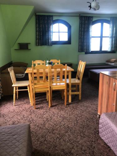 a dining room with a wooden table and chairs at Międzynarodowe Schronisko Młodzieżowe PTSM Szarotka in Zakopane