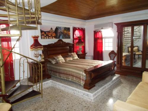 a bedroom with a bed in a room with red curtains at Castillo Romano in Las Terrenas