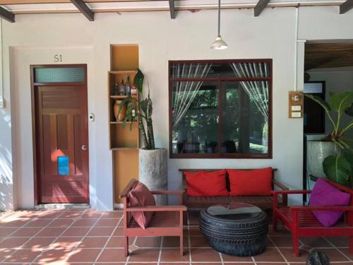 a porch with a couch and two chairs and a door at LAGI FARMSTAY in La Gi