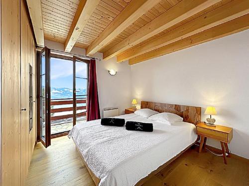 a bedroom with a large bed and a large window at Chalet Etoile Polaire in Nendaz