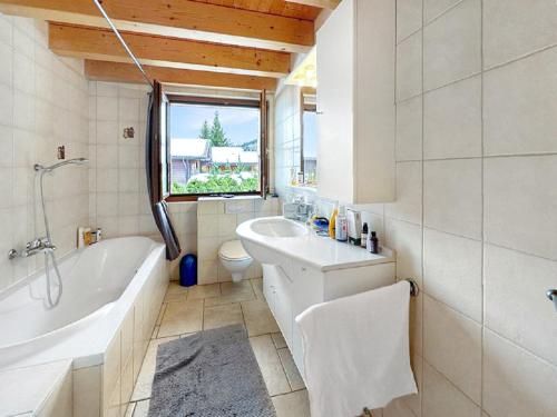 a bathroom with a tub and a toilet and a sink at Chalet Etoile Polaire in Nendaz