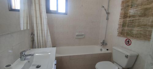 ein Badezimmer mit einer Badewanne, einem WC und einem Waschbecken in der Unterkunft Oasis Nature in Polis Chrysochous