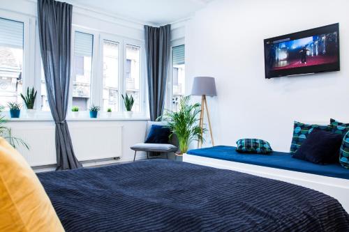 1 dormitorio con 1 cama, TV y ventanas en Five Forty Five Studios by Irundo en Zagreb