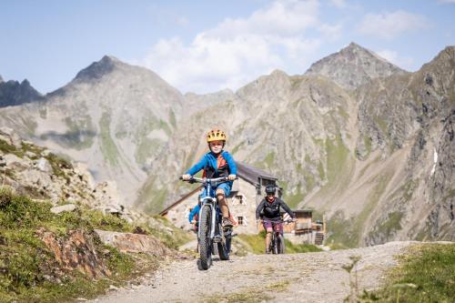 two people riding bikes on a mountain road at Ferienhaus Gundi in Pettneu am Arlberg
