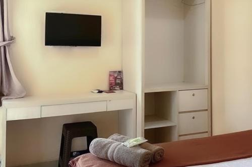 a room with a desk and a tv on a wall at Fabel Homestay in Palembang