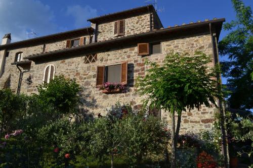 a stone building with a window and a tree at Casale Le Masse in Greve in Chianti