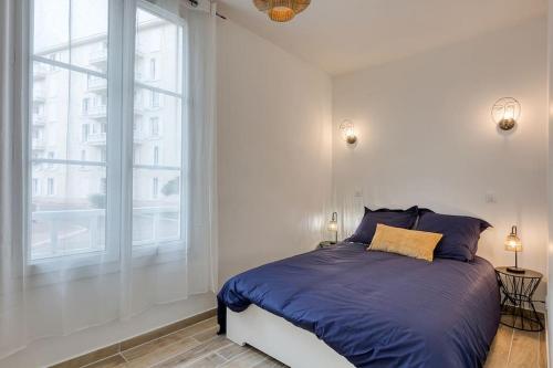 a bedroom with a bed and a large window at Bel appartement aménagé de 30m2 in Colombes