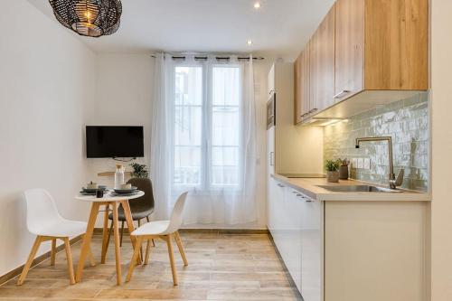 a kitchen with a table and chairs and a dining room at Bel appartement aménagé de 30m2 in Colombes