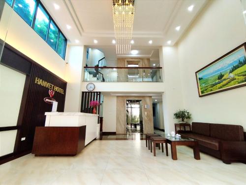 Hanvet Hotel Ha Noi في هانوي: لوبي فندق فيه كنب وطاولة