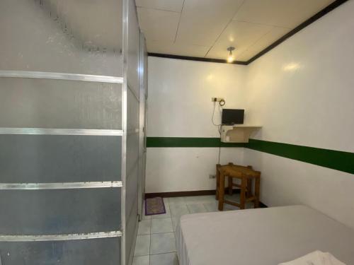 八打雁的住宿－RedDoorz @ Classique Pan Oriental Hotel and Resort Batangas，一间卧室设有一张床和绿色白色的墙壁