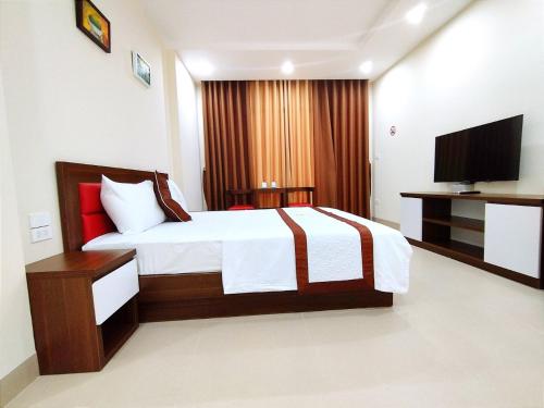 a hotel room with a bed and a television at Hanvet Hotel Ha Noi in Hanoi