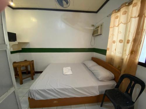 八打雁的住宿－RedDoorz @ Classique Pan Oriental Hotel and Resort Batangas，一间小卧室,配有一张床和一把椅子