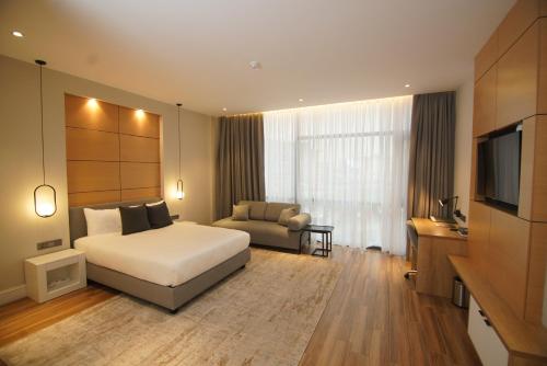 アディスアベバにあるLoft Hotel Apartmentのベッドルーム(ベッド1台、ソファ、テレビ付)