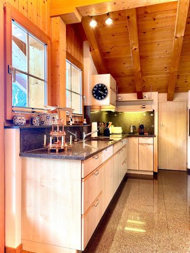 a large kitchen with wooden ceilings and a large counter at Hotel Ducan in Monstein