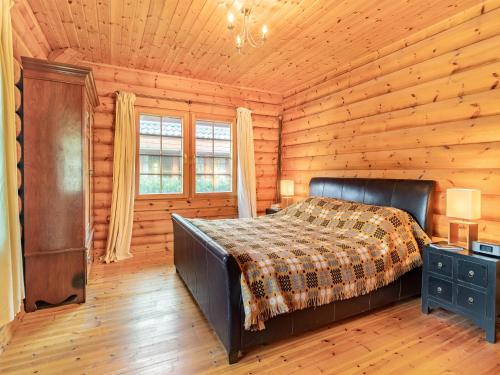 a bedroom with a bed in a log cabin at Grebe Lodge lodge 6 in Stratton Strawless