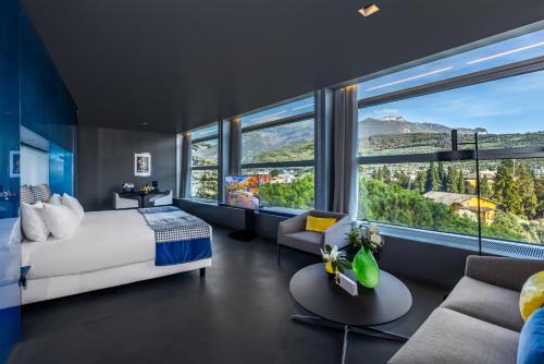 a bedroom with a bed and a large window at Lido Palace - The Leading Hotels of the World in Riva del Garda