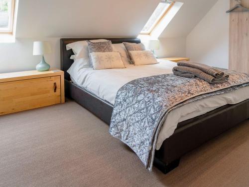a bedroom with a large bed and a night stand at Little Robins in Trotterscliffe