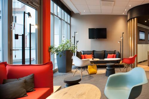 eine Lobby mit Stühlen, einem Tisch und einem TV in der Unterkunft ibis Hotel Erfurt Altstadt in Erfurt