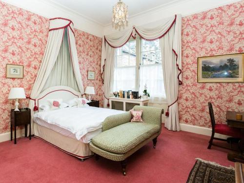 a bedroom with pink wallpaper and a bed and a chair at Lauderdale Apartment - UK30765 in Ardovie