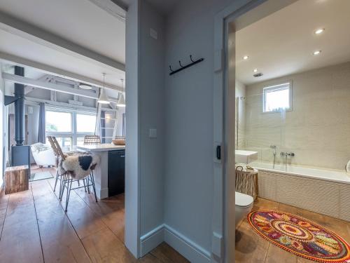 a bathroom with a tub and a kitchen with a table at Green Farm Barn in Wrenbury