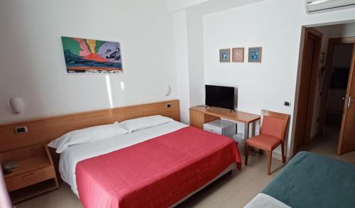 a bedroom with a bed and a desk and a television at Casa Rossa 1888 in Torre del Greco