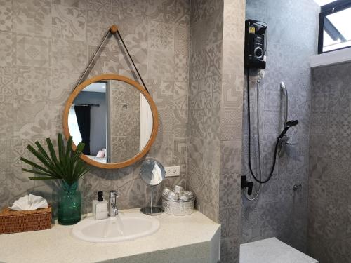 a bathroom with a sink and a shower with a mirror at Mrs. Swan Hotel 
