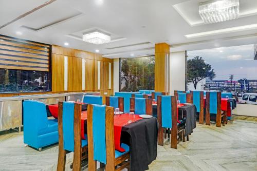 un comedor con mesas y sillas azules en Hotel Kalka Royal, en Katra