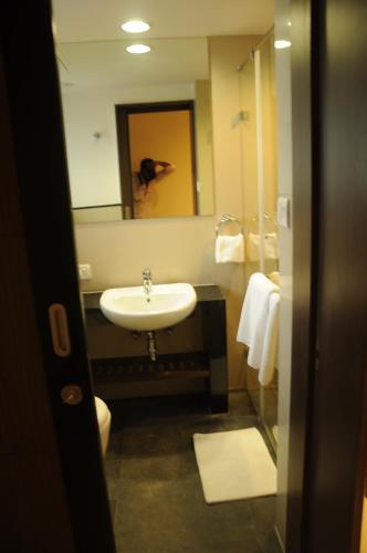 a bathroom with a sink and a mirror at Regency Sameera Vellore by GRT Hotels in Vellore